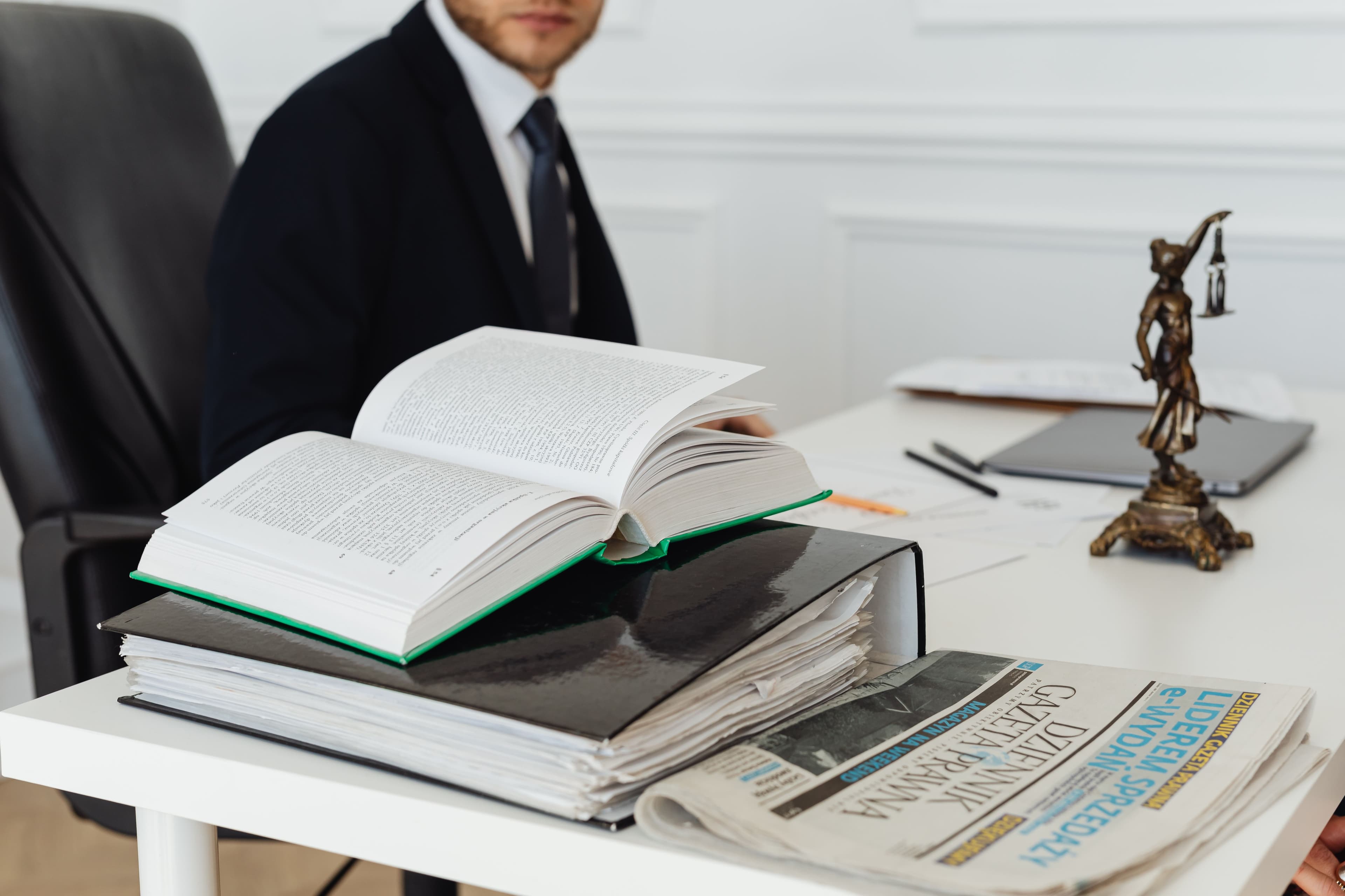 Advogado à mesa com livros e documentos jurídicos