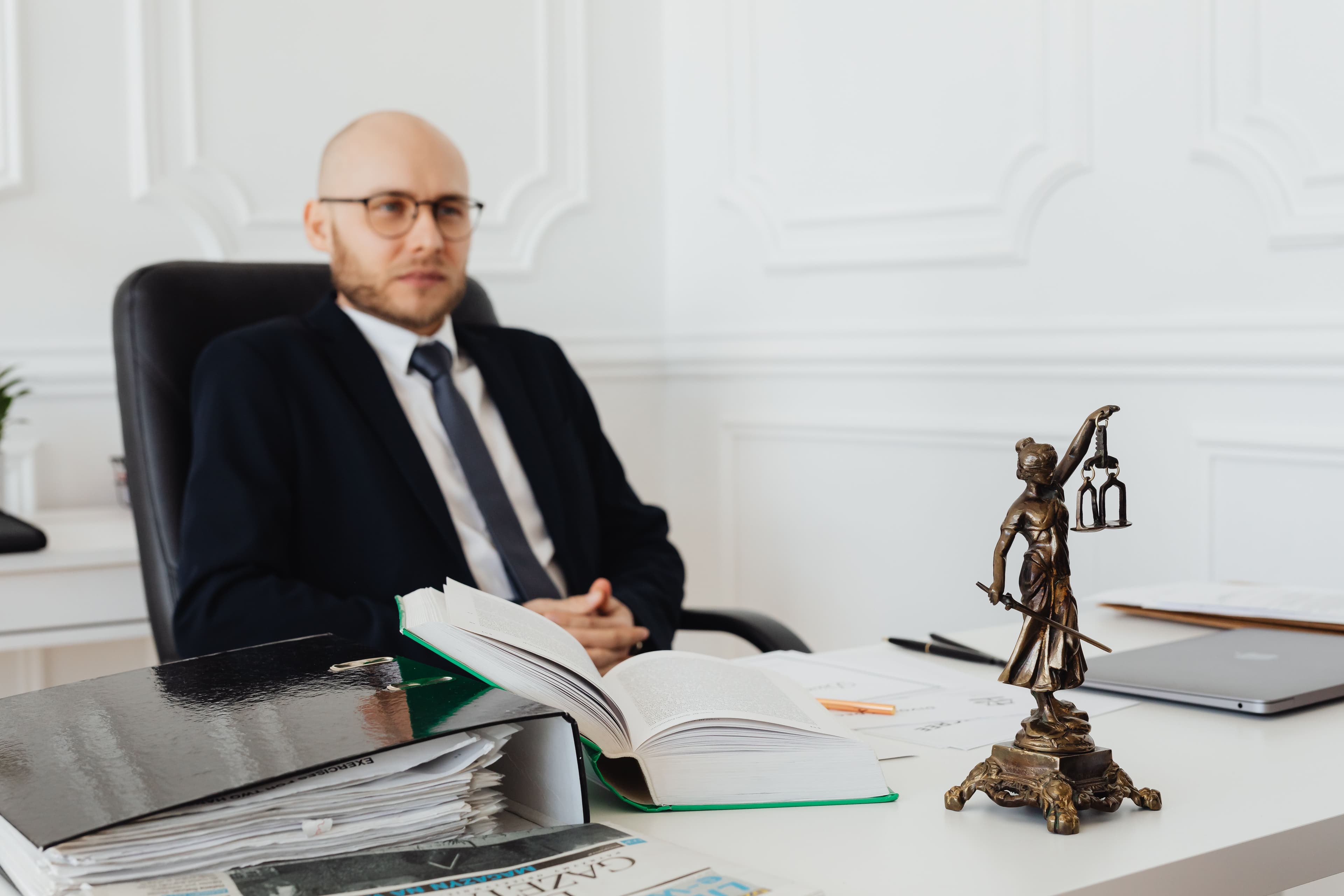 Profissional do direito no escritório com a estátua da Justiça