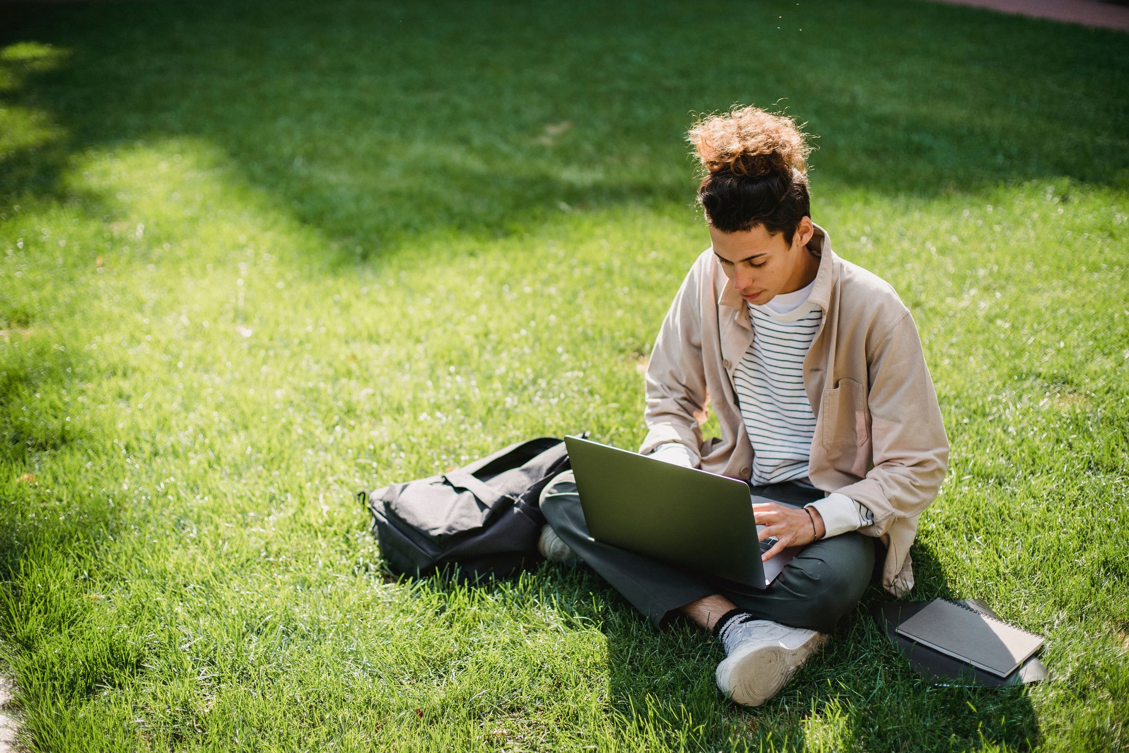 Estudante usando um notebook para estudar ao ar livre